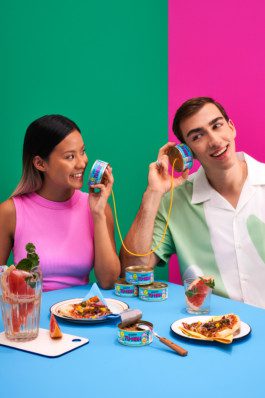 Eine Frau und ein Mann haben ein Dosentelefon von BettaF!sh sitzend an einem Tisch fotografiert von Werbefotografen Silly berlin. 